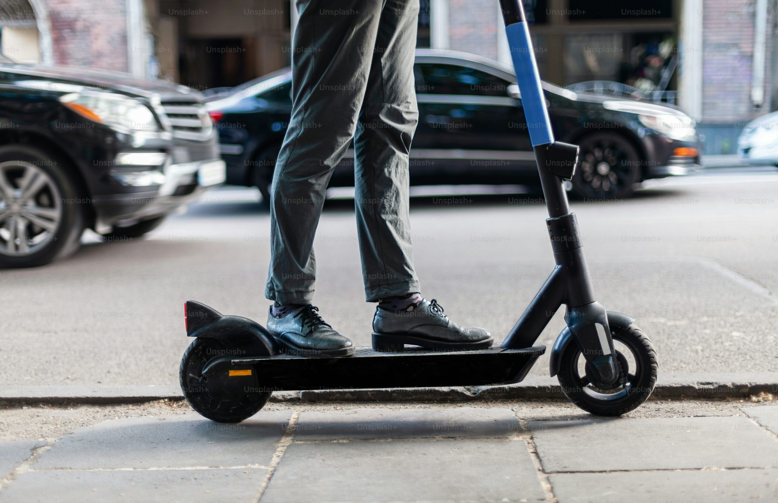 Hombre conduciendo un patinete eléctrico sobre una acera urbana, ideal para movilidad sostenible